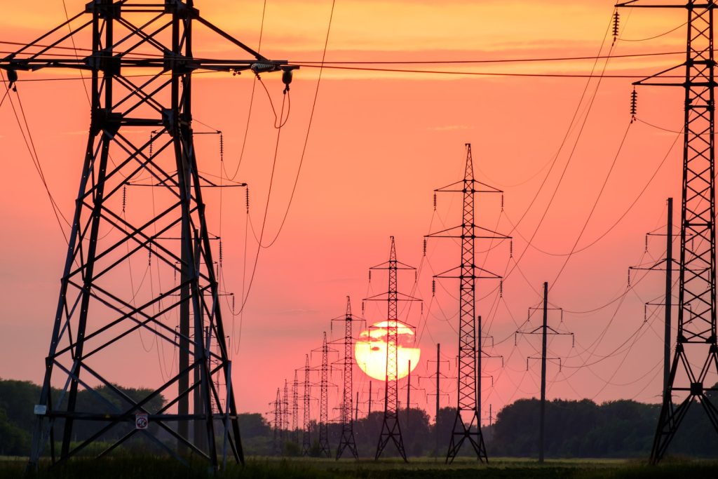 silhouette van elektriciteitsmasten met een zonsondergang bij het verbruik van elektricitieit